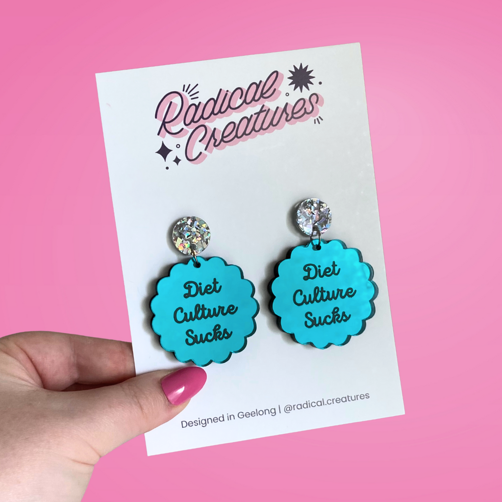 Scalloped circle shaped dangle earrings with sparkly earring topper. Teal mirror with text "diet culture sucks"