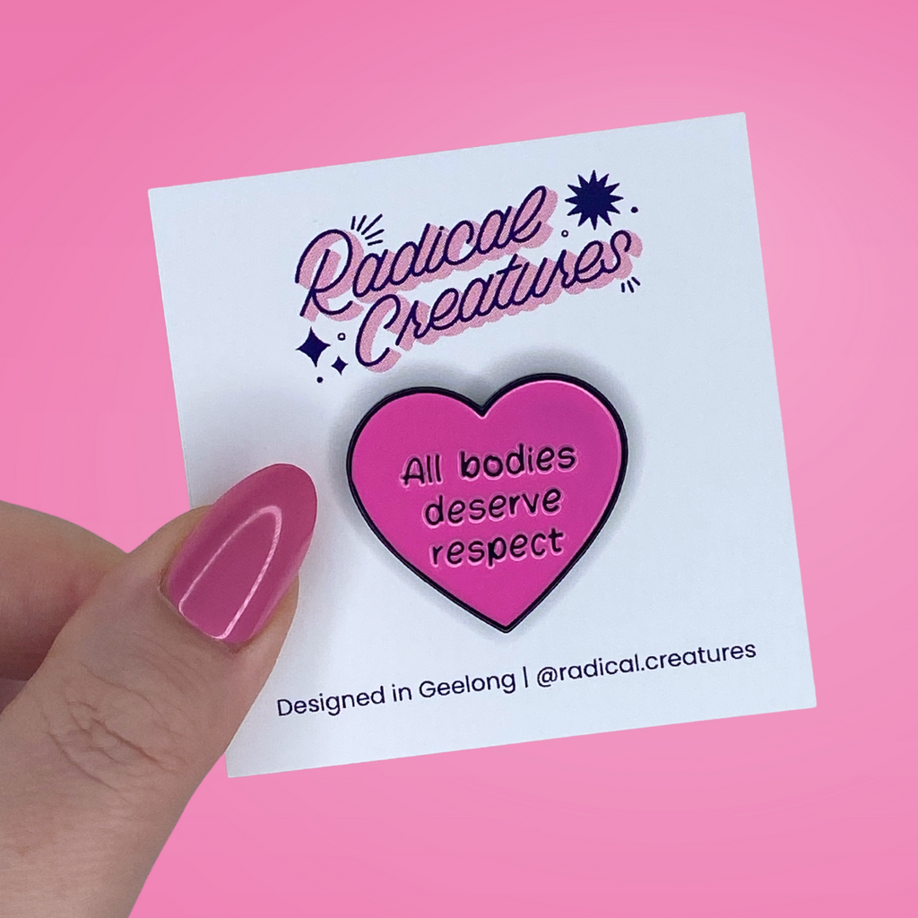 Heart shaped pin. Pink with text "all bodies deserve respect"