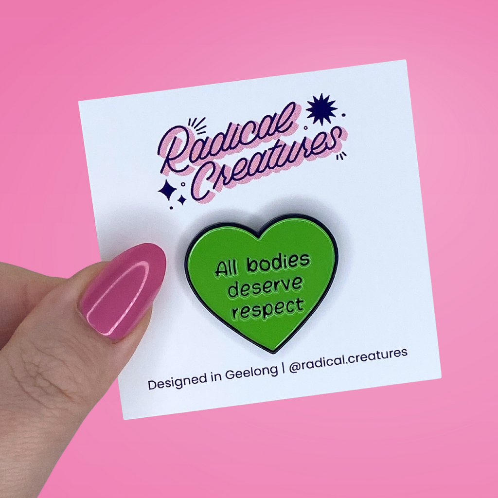 Heart shaped pin. Green with text "all bodies deserve respect"
