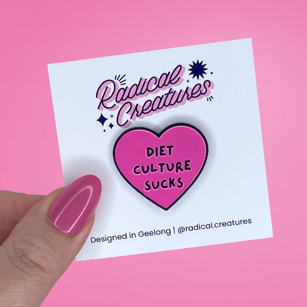 Heart shaped pin. Pink with text "diet culture sucks"