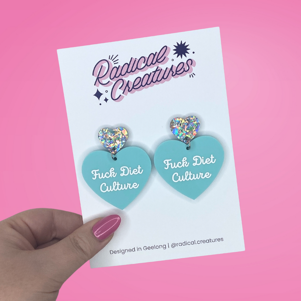 Pastel heart shaped earrings with sparkly heart shaped earring topper. Pastel mint green with words Fuck Diet Culture in white.